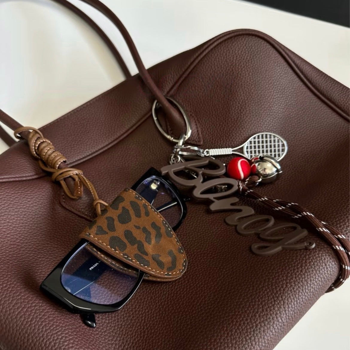 Black leather glasses holder with neck strap, designed to wear around the neck or attach to a handbag for easy everyday access.