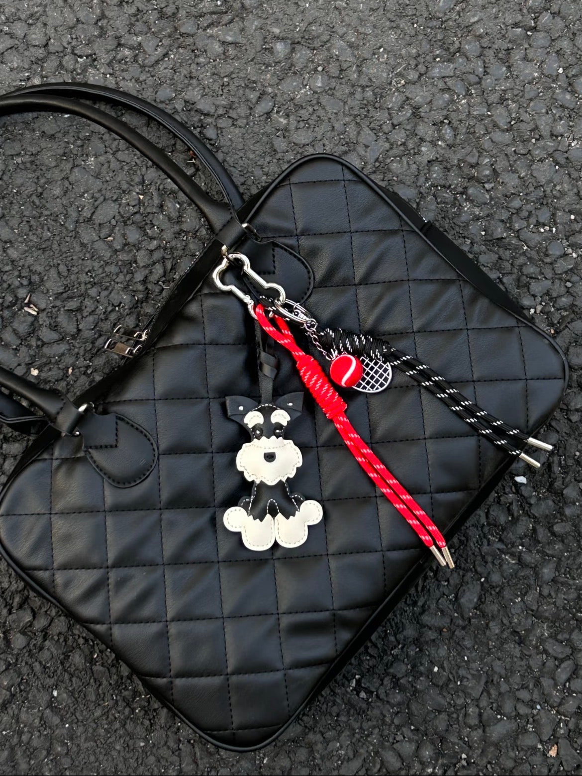 Moki Pup Charm genuine leather dog bag charm attached to a handbag, featuring a layered leather puppy silhouette.